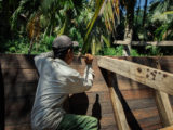 solitary man using a hammer on a boat